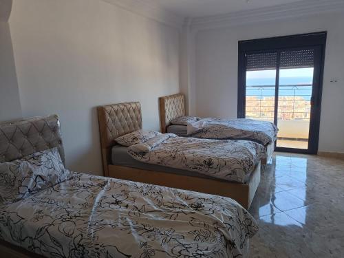 a room with two beds and a window with at Bel Horizon mosta in Mostaganem