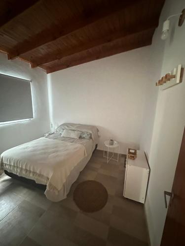 Dormitorio blanco con cama y mesa en No reservar en San Bernardo