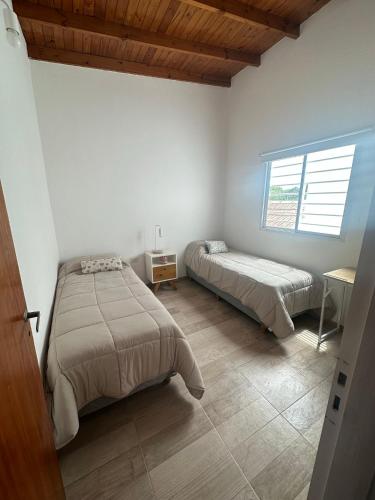1 dormitorio con 2 camas y ventana en No reservar en San Bernardo
