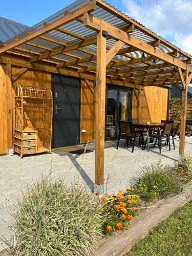 a wooden pergola with a table and chairs on a patio at Słoneczny Horyzont in Zastań