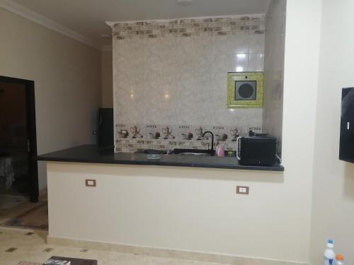 a kitchen counter with a sink and a microwave at marvel home in Quseir