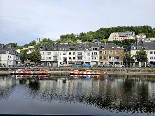 a group of boats in a river with buildings at Gîte le Carassin in Bouillon