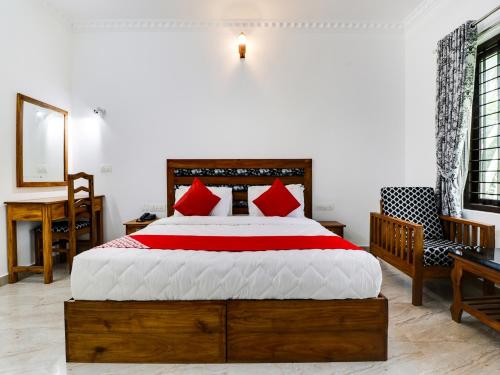 a bedroom with a large bed with red pillows at Star Inn Plus in Kovalam