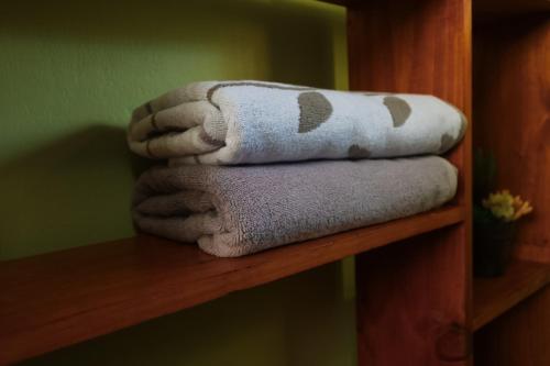 a pile of towels sitting on a wooden shelf at Cabañita del Bambú, en Santa Maria de Dota in Higueronal