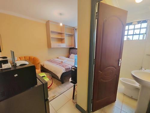 a bathroom with a bedroom with a bed and a sink at The Little Haven - Ample Parking, Views & Netflix in Kikuyu
