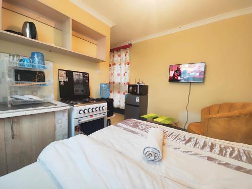 a room with a kitchen with a bed and a tv at The Little Haven - Ample Parking, Views & Netflix in Kikuyu
