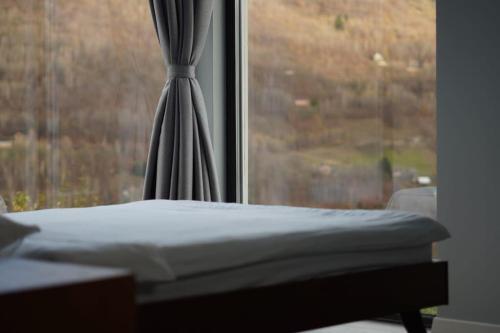 a bed sitting in front of a window at Elysium Cabin in Muntele Rece