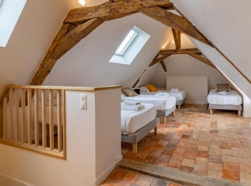 a attic room with three beds and a staircase at Gîte Apolise in Saint-Rémy-la-Varenne