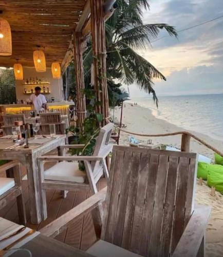 a restaurant on the beach with a view of the ocean at March Samui Resort in Mae Nam