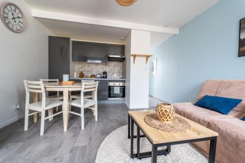 un salon avec un canapé et une table dans l'établissement Escapade à 10 min d’ETRETAT, à Criquetot-lʼEsneval