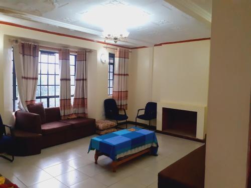 sala de estar con sofá y TV en Accommodation in Vihiga Bnb, en Koiparak