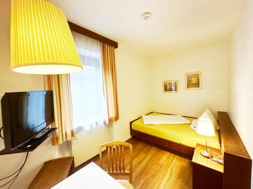 a hotel room with a bed and a television at Frühstückspension Meyer, Familie Orthacker in Graz