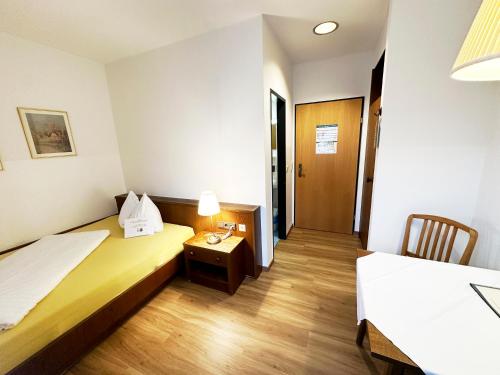 a hotel room with two beds and a table with a lamp at Frühstückspension Meyer, Familie Orthacker in Graz