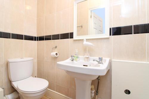 a bathroom with a toilet and a sink and a mirror at Pebbles guest house in Southampton