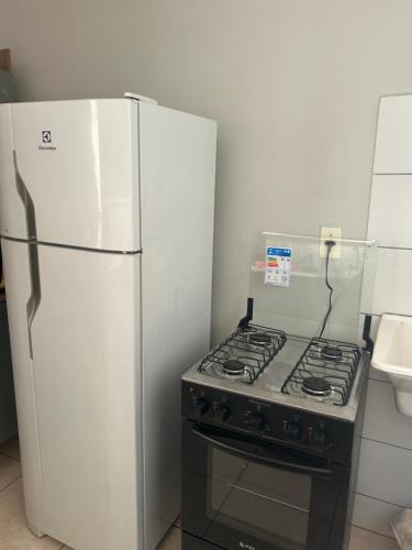 a kitchen with a stove and a refrigerator at Apartamento inteiro acomoda 5 pessoas in Uberlândia
