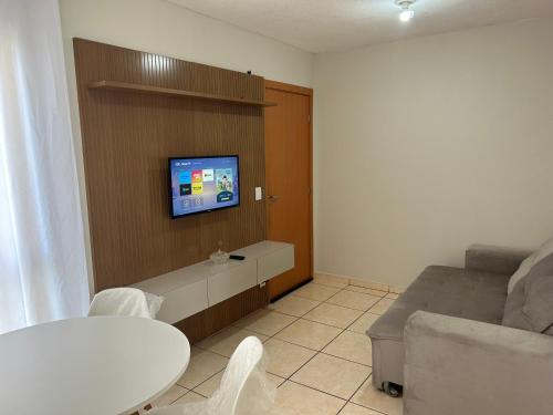 uma sala de estar com um sofá e uma televisão na parede em Apartamento inteiro acomoda 5 pessoas em Uberlândia