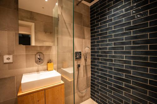 a bathroom with a sink and a glass shower at Hochwertige Ferienwohnung Hochsitz in Saulgrub