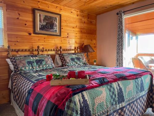 a bedroom with a bed with a wooden wall at Luxurious Pigeon Forge Cabin, w/ HotTub, EasyDrive, Arcade Game, Panoramic Views in Pigeon Forge