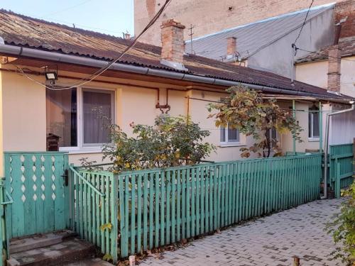 a green fence in front of a house at Emese Central Vintage Apartment in Târgu-Mureş