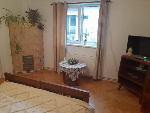 a bedroom with a bed and a table and a window at Emese Central Vintage Apartment in Târgu-Mureş