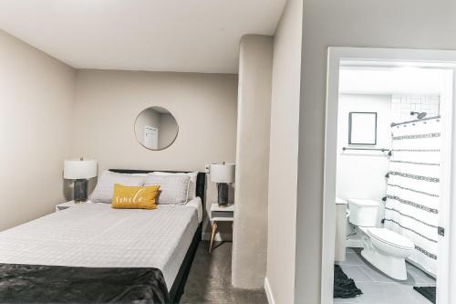 a white bedroom with a bed and a toilet at Downtown/Bengals/Reds/TQL/OTR in Cincinnati