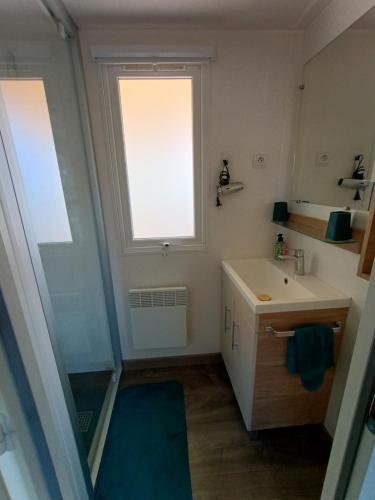 une salle de bain avec un lavabo et une fenêtre dans l'établissement Camping SIBLU les sables du midi à Valras plage, à Valras-Plage