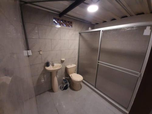 a bathroom with a shower and a toilet and a sink at Acogedor apartamento in Manizales