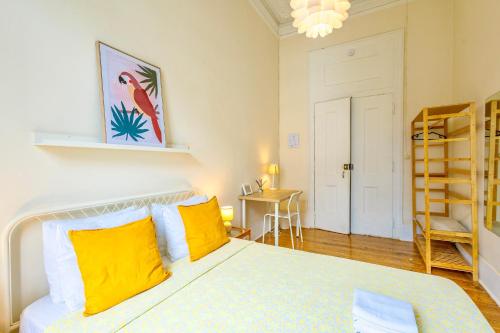 a bedroom with a bed with yellow pillows and a ladder at Ambiente Hostel in Lisbon