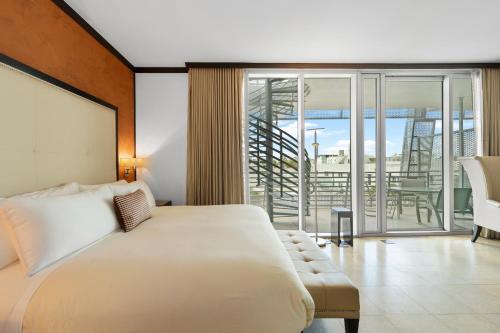 um quarto com uma cama e uma varanda em Prime Location Penthouse South Beach Condo Rooftop Balcony steps to Ocean Drive and Beach em Miami Beach