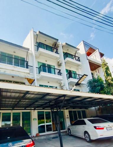 a white building with a car parked in front of it at S304 Good Apartment Chalong Na-Kok Mauy-Thai in Ban Na Kok