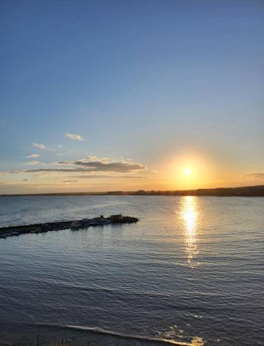 a large body of water with the sun setting in the distance at Úchvatný výhled na moře in Aheloy