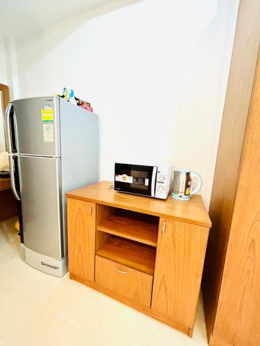 a kitchen with a refrigerator and a microwave on a counter at S304 Good Apartment Chalong Na-Kok Mauy-Thai in Ban Na Kok