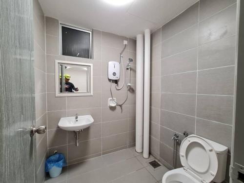 een badkamer met een toilet, een wastafel en een spiegel bij Homestay Epoh Meru Raya F3 with Netflix in Ipoh