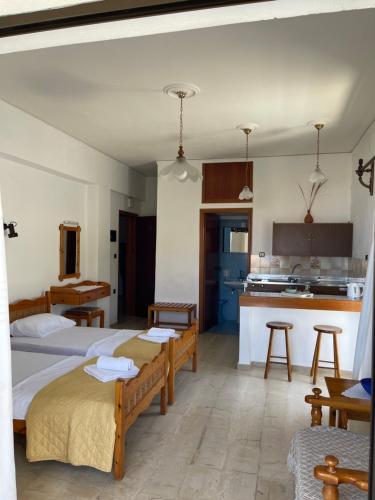 a bedroom with two beds and a kitchen at Aeolos Apartments Kolymbari in Kolymvari