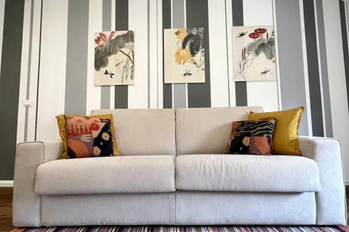 a white couch in a living room with striped walls at Appartamento Elegante Teatro Rossetti in Trieste