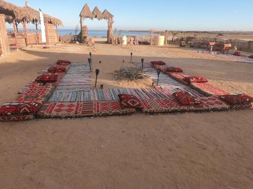 a row of tables on a beach with cars on it at flamingo camp in Dār as Salām