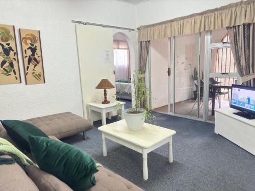a living room with a couch and a tv at Busa House in White River