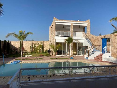 una casa con piscina frente a ella en Jolie propriété de campagne calme et spacieuse 