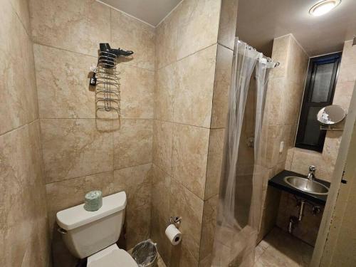 a bathroom with a shower and a toilet and a sink at Hotel-Studio @ The Mansfield Midtown in New York