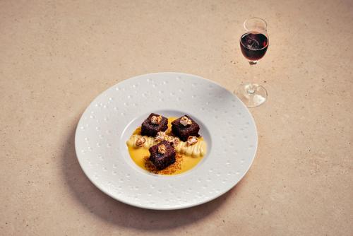 a plate of food on a table with a glass of wine at Agriturismo Podere Casato in Castelnuovo Berardenga