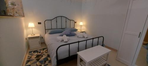 a bedroom with a bed with blue pillows and two lamps at CASA JO in Bari