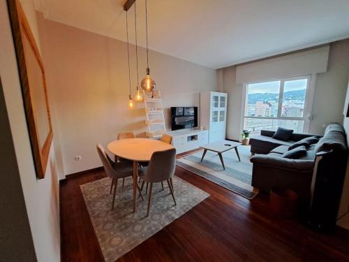 een woonkamer met een tafel en een bank bij 2 habitaciones en piso Bilbao in Bilbao