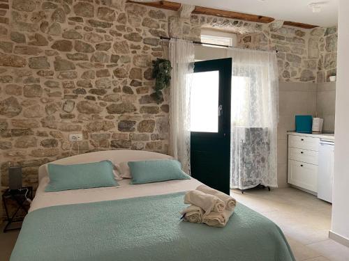 ein Schlafzimmer mit einem großen Bett und einer Steinmauer in der Unterkunft Violet in Vis