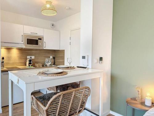 uma cozinha com uma ilha branca com duas cadeiras em Escale Dinardaise - Garage - 2km de la mer em Dinard