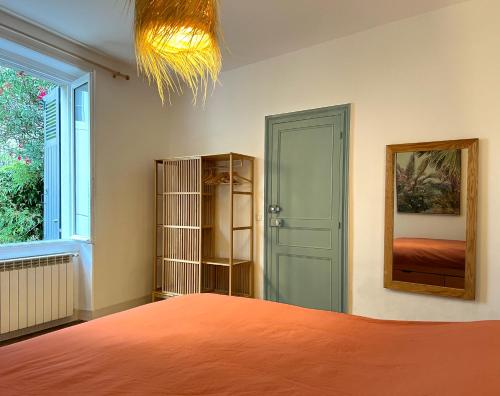 1 dormitorio con cama, espejo y ventana en Etxea Zoriontsua, en Biarritz
