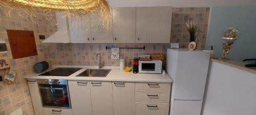 a kitchen with a white refrigerator and a microwave at CASA JO in Bari