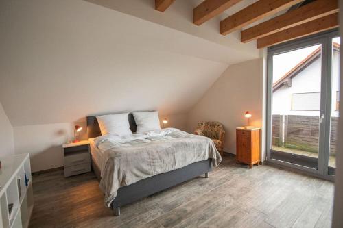 ein Schlafzimmer mit einem Bett und einem großen Fenster in der Unterkunft Odenwaldblick in Lützelbach