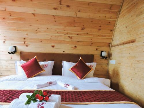 two beds in a room with wooden walls at Royal Adventures in Kodaikānāl