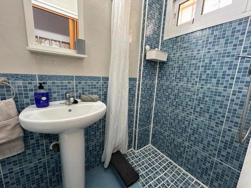 y baño de azulejos azules con lavabo y ducha. en Agata Views en Benalmádena