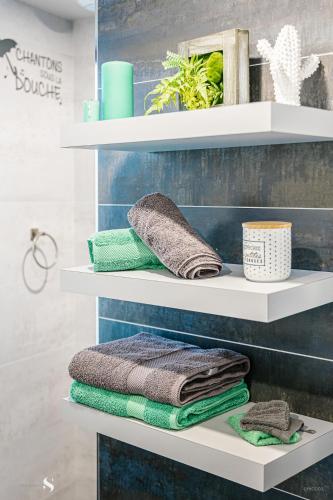 - une étagère avec des serviettes dans la salle de bains dans l'établissement Au Pied des Vignes, à Saint-Pourçain-sur-Sioule